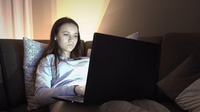 Happy smiling female teenager e-learning sitting on sofa at home during corona quarantine isolation