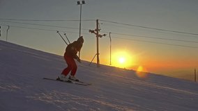 4K Sunset ski. Woman skier go down on ski route down against mountain slopes. UHD steadycam stock video