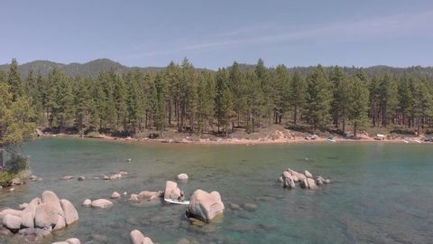 Lake Tahoe, NV/USA - August 24, 2019: Lake Tahoe's clear blue waters attract tourist beach goers and stand-up paddle boarders during summer months.