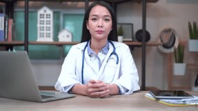 Asian woman doctor talk by conference video call chat consult to patient online, distant medical consultation and social distancing concept.