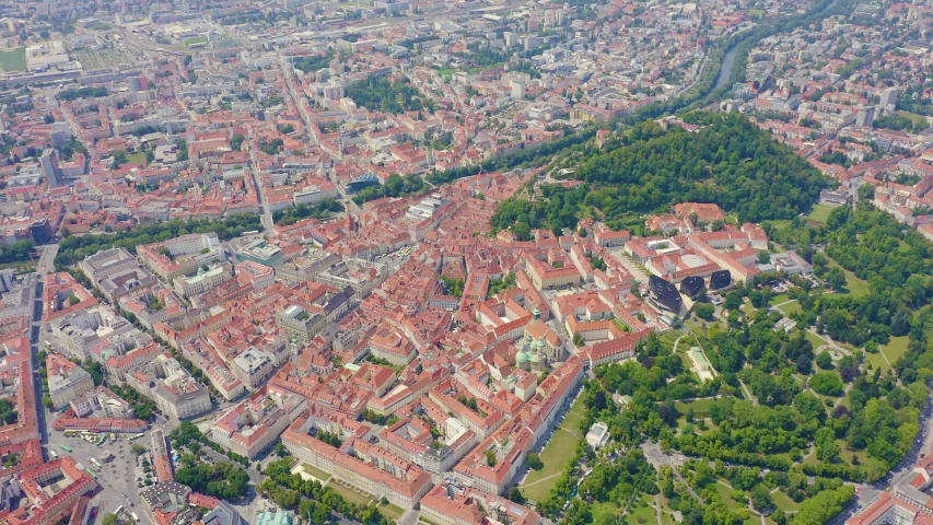 Graz, Austria. The historic city center unfolds in a sweeping aerial view, revealing a dense tapestry of red terracotta roofs that defines one of Central Europe