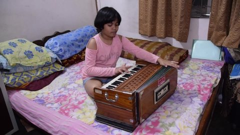 Delhi - India
10/04/2020
An Indian child playing musical instrument Harmonium