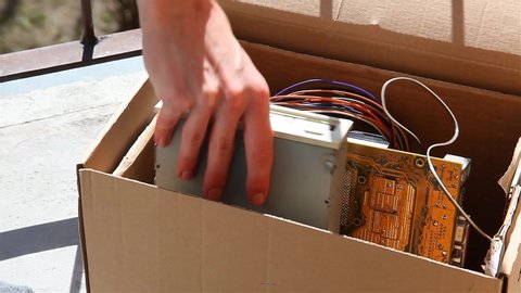 Throwing away electronic waste, man putting old obsolete pc components into a box closing it and taking it away, electro trash recycling, old computer parts trashing, eco safe electronics disposal