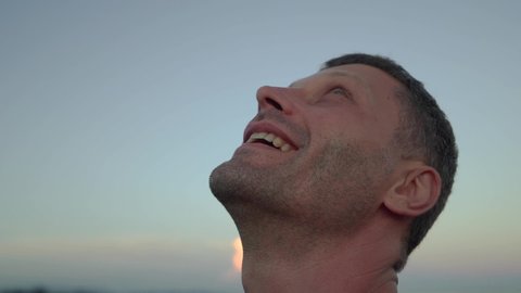Attractive middle aged man smiling and looking up the sky