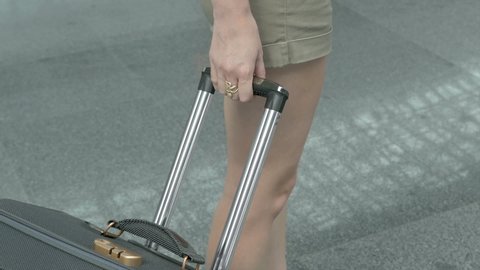 Girl with a suitcase is walking at the airport