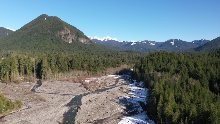 Aerial / drone footage of the winter Cascade range and Nisqually River, draining glaciers by Mt. Rainier National Park in Washington
