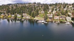 Aerial / drone footage of the empty Clyde Beach Park with Lake Washington waterfront mansions in Belleview, near Medina and Seattle, Washington during the COVID-19 pandemic