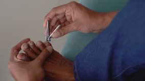 hand doing nail clipping on toes nail at home