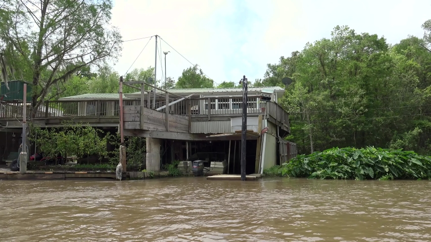 Vacherie, Louisiana / USA - APRIL 13, 2019:
Swamp houses & fishing shacks at the Honey Island swamp. View from a moving boat.