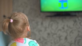 child watches TV at home. children in self-isolation mode. little girl watching cartoons