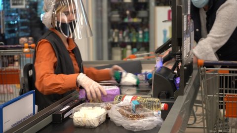 Europe, Kiev, Ukraine - April 2020: a buyer in a medical mask pays for products at the checkout in a supermarket during the Covid-19 coronavirus pandemic. Cash desk at the supermarket.