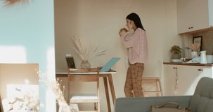 Young mother working from home surrounded by daughter and dog, having a work video call. Stay home, quarantine remote work. Shot on RED Dragon