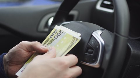 Man counting euro bills sitting in a car, Close up of male hands count money cash. Concept of earnings or bribes, insurance or credit, investing