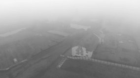 Morning flight in the fog over an Orthodox monastery. Black and white video. Beautiful view of Zimnensky Svyatogorsky monastery from above. View of the domes and the Assumption Cathedral.