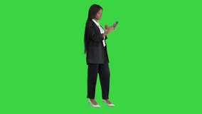 Beautiful afroamerican woman smiling at her phone shooting a selfie on a Green Screen, Chroma Key. - Powered by Shutterstock - Get 15% off with code: PIKWIZARD15