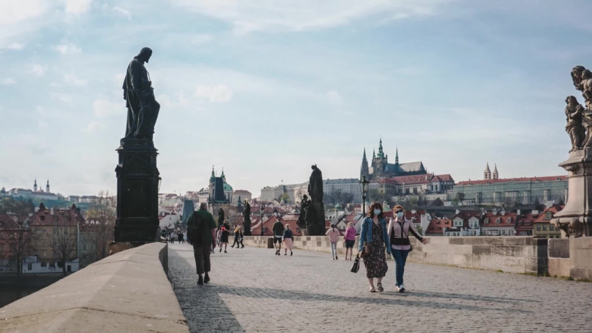 Timelapse, people crossing Charles Bridge and Prague Castle