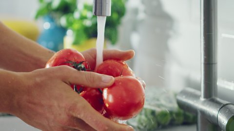Slow Motion Close Up Footage of a Man Washing Tomatoes with Tap Water. Authentic Stylish Kitchen with Healthy Vegetables. Natural Clean Products from Organic Farming Washed by Hand.