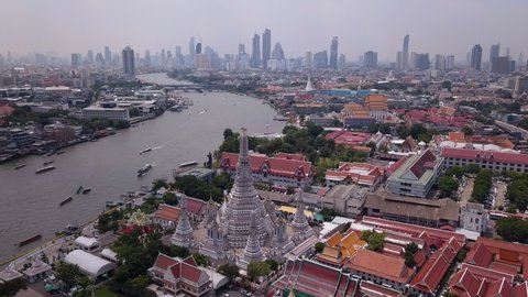 Aerial drone view of Bangkok city in Thailand. Busy water traffic in the main river of Bangkok. Asian city real estate development with heavy traffic and modern skyscrapers in the background. 