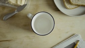 Morning coffee pouring into cup top down view. Closeup of a white cup of coffee and toast. Available in 4K and HD. This tea video clip is suitable for breakfast scenes. Download here.