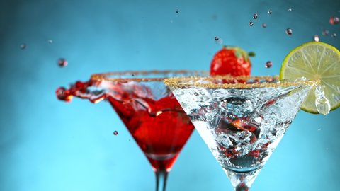 Super Slow motion shot of strawberry falling into martini.