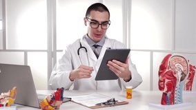 Medical Professional Doctor, video chatting with his patient using his tablet computer devise technology, to explain how to use the medication and what side effects to expect.