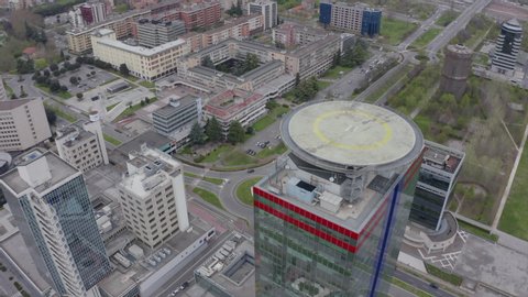 Aerial view of Brescia, Lombardy, Italy during COVID-19 lockdown. Building with helipad on roof, helicopter platform, houses, deserted roads with no traffic. Drone flying in the sky over Italian town