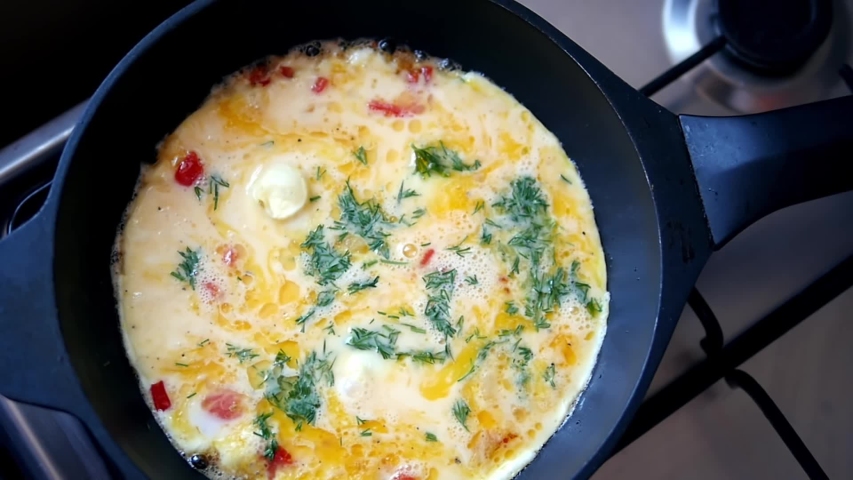 Healthy breakfast homemade omelet with greens in a pan. Egg