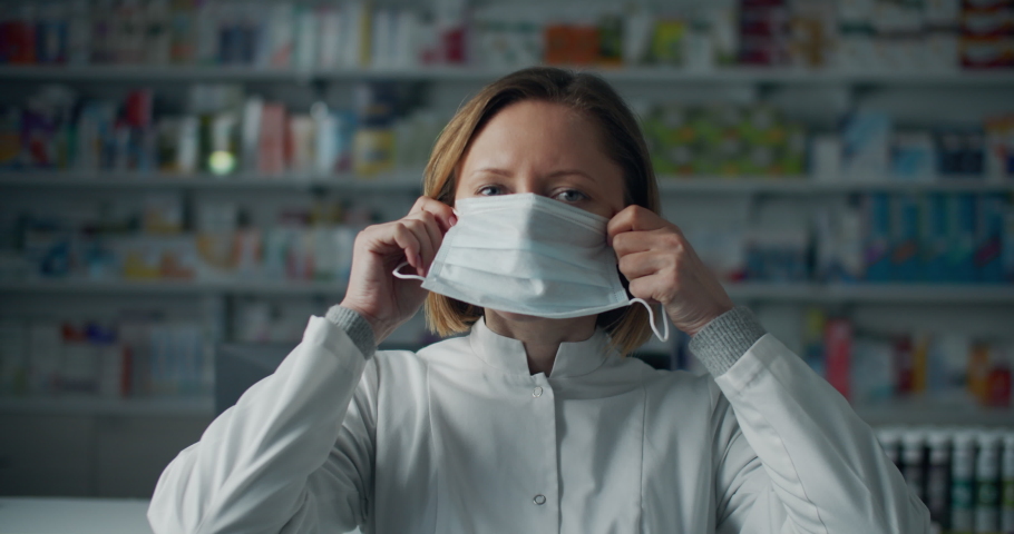 Serious female pharmacist with face mask at work, coronavirus protection. Virus protection. Female portrait. | Shutterstock HD Video #1050411334
