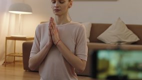 CU Attractive Caucasian female recording making live stream or vlog about doing yoga at home. Stay home, quarantine workout. Shot on ARRI Alexa Mini with Cooke S4 lenses