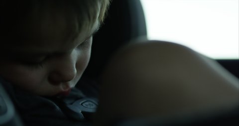 Toddler boy sleeping in car seat on long journey - close up on face