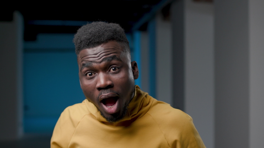30s Young Handsome Funny African Man Looking Shocked and Astonished. Attractive Smart Ethnic Guy Standing Indoors with Emotional Amazed Glance Staring at Camera. Individuality Surprise Face Expression | Shutterstock HD Video #1050431617