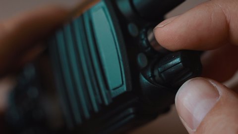Hand turn on the walkie-talkie indoors close-up macro