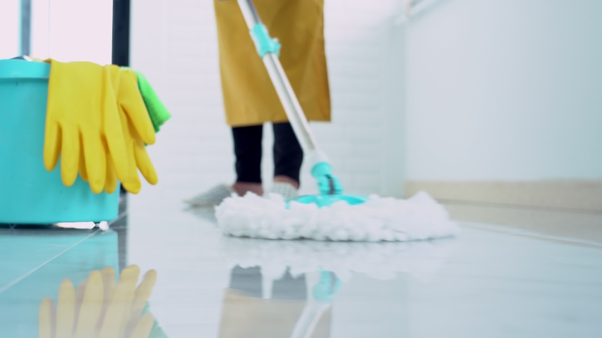 4k video of Woman housekeeper with mop and bucket with cleaning agents for cleaning floor at home, Floor care and cleaning services | Shutterstock HD Video #1050439282