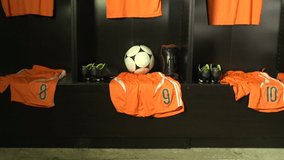 Soccer /  Football Changing room / Locker room. All the kit or uniform is laid out ready for the players. Unbranded Ball. Crane Shot. Stock Video Clip Footage