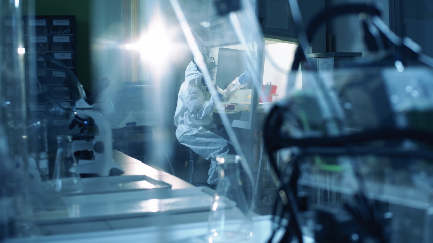 Virologist in hazmat works in laboratory while creating vaccine. Coronavirus, COVID-19, 2019-ncov medicines research concept. Royalty-Free Stock Footage #1050442996