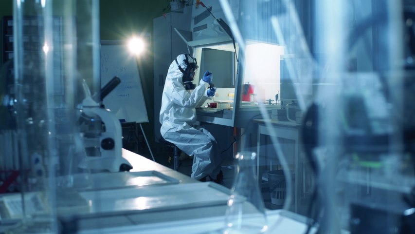 Virologist in hazmat works in laboratory while creating vaccine. Coronavirus, COVID-19, 2019-ncov medicines research concept.