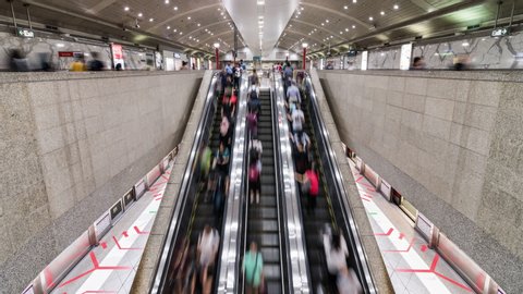 Singapore, Singapore - Feb 6, 2020: Asian people walk and use escalator at MRT subway underground station. Public transportation, Asia everyday city life, or commuter urban lifestyle concept. Zoom out