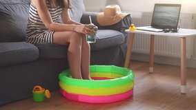 Funny home summer isolation caused by coronavirus quarantine. Young woman with baby pool and laptop screen with waves - Powered by Shutterstock - Get 15% off with code: PIKWIZARD15
