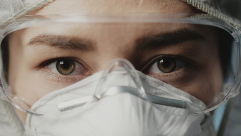 Eyes of female healthcare professional doctor in a hospital operating theatre wearing a surgical cap and mask. Healthcare workers in the Coronavirus Covid19 pandemic. Health versus virus and epidemic