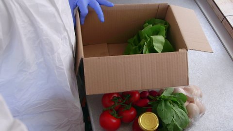 On line food delivery services during coronavirus pandemic for working from home and social distancing. Shopping online. The courier collects food box for home delivery. Meals Food Donations.