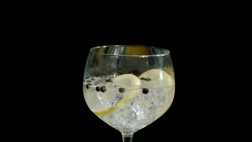 Rosemary falling into a fresh gin and tonic on an isolated black background in super slow motion Royalty-Free Stock Footage #1050468307