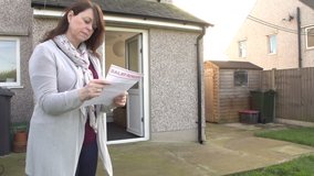 Woman reading letter from Bailiff as Debt Collector takes her TV from her house. Repossession. Repo Man. Stock Video Clip Footage. Slow Motion