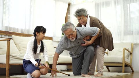 Elder senior man falling on floor after just start walking. Mature woman and neice, granddaughter feeling shock coming to help grandfather immediately. Elderly retirement people health, sick concept.
