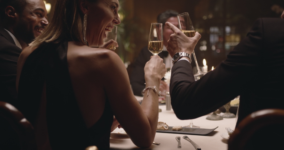 Group of cheerful people cheering with drinks and looking happy. Group of men and women enjoying dinner at a gala night.
 Royalty-Free Stock Footage #1050478054