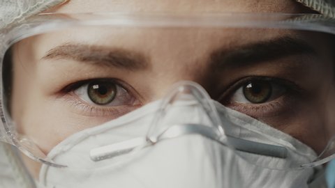 Portrait of confident doctor woman face, close-up. eyes with safety glasses and protective mask. Research Laboratory Officer. 2019 Novel Coronavirus (2019-nCoV), COVID-19, pandemic, isolation concept.