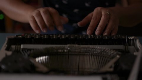 Close up hands of woman typing on retro typewriter during working at home. Thai alphabet typewriter. 