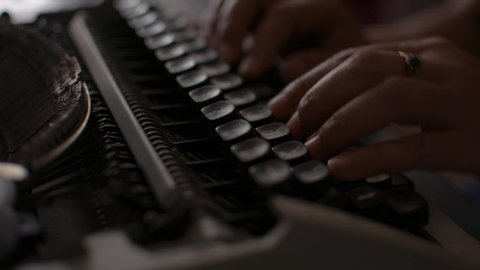 Close up hands of woman typing on retro typewriter during working at home. Thai alphabet typewriter. 