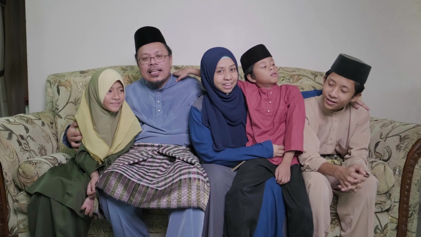 A group of happy malay family all wearing traditional malay costumes during Hari Raya festive | Shutterstock HD Video #1050508066