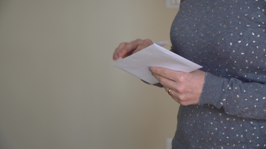Woman reads received news holds documents paper letter feels desperate about financial problems, domestic bills or debt Royalty-Free Stock Footage #1050514375