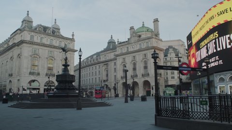 LONDON, ENGLAND, UK – April 14 2020: Lockdown London, Empty Piccadilly Circus, Eros statue and underground station during coronavirus pandemic, no people